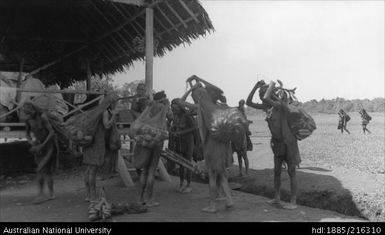 Native women arriving at Atemble Mission with their loads of native foods - 1 Aug 1937 10.30 am bright