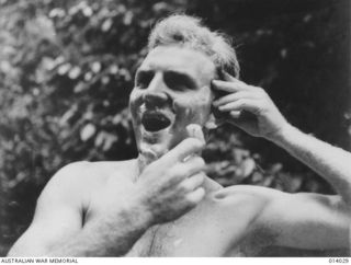 Informal portrait of Pilot Officer (PO) John S (Jack) Archer, No. 4 Squadron, RAAF, shaving. On 26 December 1942 PO Archer, with his observer Sergeant J L (Les) Coulston, both from Melbourne, Vic, ..