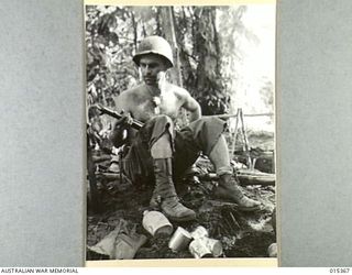 1943-07-31. ALLIED CAPTURE OF MUBO. A TYPICAL AMERICAN INFANTRYMAN, PTE. GEORGE BURTON, OF SOUTH RIVER, NEW JERSEY, CLEANING HIS RIFLE NEAR MUBO. (NEGATIVE BY G. SHORT)