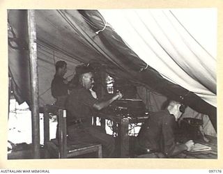 MALAGUNA, RABAUL, NEW BRITAIN. 1945-09-25. MEMBERS OF 13 INFANTRY BRIGADE SIGNAL SECTION AT WORK IN THE SIGNAL OFFICE. IDENTIFIED PERSONNEL ARE:- SERGEANT C.H. GRAHAM (1); SIGNALMAN N. BROWN (2); ..