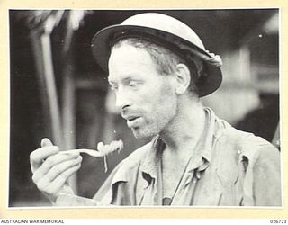 PAPUA. 1942-09. PRIVATE JACK SCALLY OF THE 2/27TH INFANTRY BATTALION WHO HAD BEEN OUT OF TOUCH FOR 16 DAYS AFTER BEING CUT OFF DURING A RETREAT IN ONE OF THE FIERCE ATTACKS NEAR MYOLA LAKE