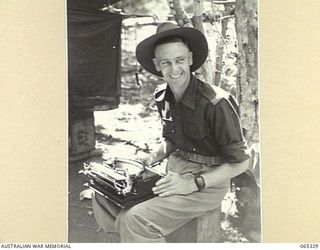 KILIGIA, NEW GUINEA. 1944-03-20. SX23588 SERGEANT THOMAS HENRY FARRELL OF THE PUBLIC RELATIONS FIELD UNIT, USING HIS TYPEWRITER ON HIS LAP