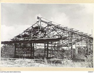 ONE OF THE FEW BUILDINGS NOT COMPLETELY RAZED AROUND KAVIENG. THIS WAS A STORE AND GARAGE. AN AUSTRALIAN NEW GUINEA ADMINISTRATIVE UNIT ADMINISTRATIVE HEADQUARTERS IS BEING SET UP AT KAVIENG WITH ..