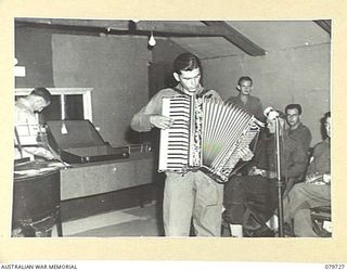 BOSLEY FIELD, BOUGAINVILLE, SOLOMON ISLANDS. 1945-03-15. ACCORDIONIST QX42727 PRIVATE WHITAKER, HEADQUARTERS 29TH INFANTRY BRIGADE OF MARYBOROUGH, QLD (1) COMPETING IN THE AMATEUR PROGRAMME "STARS ..