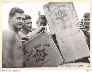 JACQUINOT BAY, NEW BRITAIN. 1944-12-07. CORPORAL M.H. HAKAINSSON, (3), AMONG TROOPS AT HQ 5 DIVISION UNLOADING THE FIRST AUSTRALIAN COMFORTS FUND CHRISTMAS HAMPERS TO ARRIVE BY BARGE FOR ..