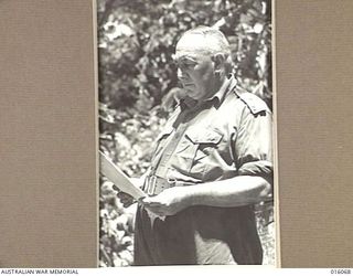 Informal portrait of Major-General G F Wootten, General-Officer-Commanding 9th Division, taken at a forward past during operations in the Finschhafen area