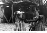 Rongelap girls eating by a cookhouse, summer 1964