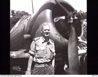 FINSCHHAFEN, NEW GUINEA. 1943-10-30. SX9038 MAJOR P. E. SIEKMAN, OFFICER COMMANDING "C" COMPANY, 2/3RD AUSTRALIAN PIONEER BATTALION STANDING IN FRONT OF A WIRRAWAY AIRCRAFT OF NO. 4 SQUADRON (ARMY ..