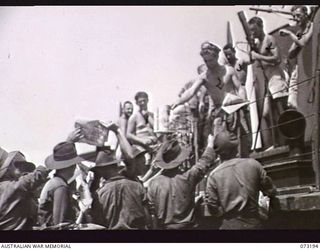 ALEXISHAFEN, NEW GUINEA. 1944-05-14. TROOPS IN THE FORWARD AREA OF THE 4TH INFANTRY BATTALION AT THE OLD JETTY RECEIVING NEWSPAPERS AND MAGAZINES FROM THE CREW OF HMA MOTOR LAUNCH 806 RAN. ..