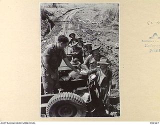 YAMIL 3, NEW GUINEA, 1945-07-23. MESS IS TRANSPORTED OUT TO ENGINEERS OF 2/24 FIELD COMPANY, ROYAL AUSTRALIAN ENGINEERS, WHO ARE MAINTAINING THE MAPRIK-YAMIL ROAD. HERE THEY ARE SEEN LINING UP ..