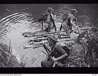 DONADABU, SOGERI VALLEY, NEW GUINEA. 1943-06-28. TROOPS OF "B" COMPANY, 25TH INFANTRY BATTALION ON AN IMPROVISED ASSAULT RAFT MADE OF BAMBOO POLES LASHED TOGETHER. QX35169 PRIVATE (PTE) G. H. D. ..