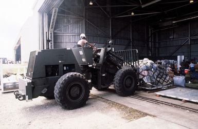 A US Air Force M220BFL rough terrain fork lift moves a pallet of luggage of evacuees from the Philippine Islands. The evacuation is the result of the June 10 eruption of Mount Pinatubo, which deposited more than four inches of volcanic ash on the Islands. More than 20,000 evacuees have been removed from the area as a part of the US military's Operation Fiery Vigil