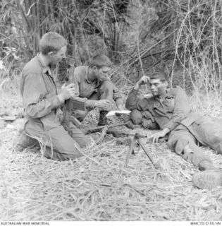 PHUOC TUY PROVINCE, SOUTH VIETNAM. 9 MARCH 1970. A FINAL BRIEFING IN THE JUNGLE FOR THESE SOLDIERS FROM 7TH BATTALION, THE ROYAL AUSTRALIAN REGIMENT (7RAR), BEFORE MOVING OUT ON OPERATION ..