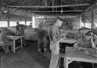 Lae, New Guinea. 1944-07-27. Members of 22 Platoon, F Company, 2/1st Guard Regiment, in the unit Recreation Hut. Identified personnel are:- Private (Pte) B. W. Butler (1); Pte J. Dryburgh (2); Sgt ..