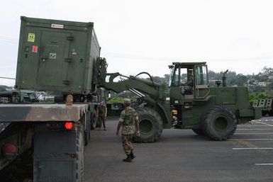 US Marine Corps (USMC) Marines assigned to Combat Service Support Group 3 (CSSG-3), Marine Forces Pacific (MARFORPAC) uses a Rough Terrain Forklift to upload a Combat Camera and Printing (CC&P) portable transport van onto a transport truck at Camp H.M. Smith, Hawaii (HI), as the Unit prepares for deployment to Iraq, in support of Operation IRAQI FREEDOM