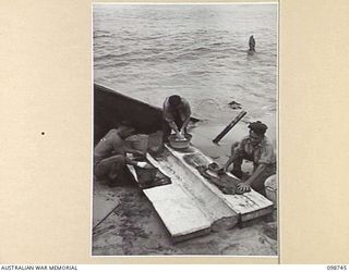 BORAM, NEW GUINEA. 1945-11-16. PERSONNEL OF 3 BASE SUB AREA, AUSTRALIAN ARMY CANTEENS SERVICE, LAUNDERING THEIR CLOTHES ON THE BEACH. IDENTIFIED PERSONNEL ARE:- PRIVATE L.T. HAMILTON (1); PRIVATE ..