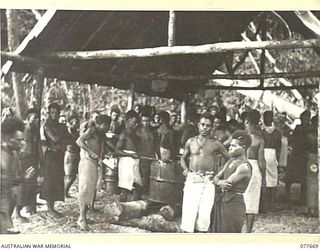 JACQUINOT BAY, NEW BRITAIN. 1944-12-13. A NATIVE MESS PARADE IN PROGRESS AT THE AUSTRALIAN NEW GUINEA ADMINISTRATIVE UNIT NATIVE COMPOUND AT THE MOUTH OF THE MALOPI RIVER