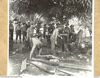 FINSCHHAFEN AREA, NEW GUINEA, 1943-10-23. GENERAL VIEW OF THE YOUNG MEN'S CHRISTIAN ASSOCIATION (YMCA) COFFEE STALL IN THE 9TH AUSTRALIAN DIVISION AREA AS TROOPS LINE UP WAITING FOR THE COFFEE TO ..