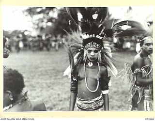 HIGITURA, NEW GUINEA. 1944-04-27. A YOUNG OROKAIVAN DANCER WEARING A BRILLIANT HEADDRESS MADE FROM BIRD OF PARADISE FEATHERS, AT A SPECIAL NATIVE DANCE CEREMONY HELD TO HONOUR THE VISIT OF THE ..