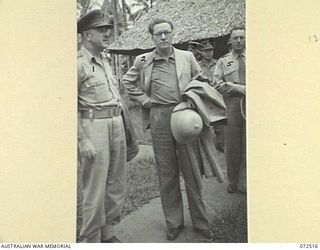MILNE BAY, NEW GUINEA. 1944-04-20. THE HONOURABLE E.J. WARD, MINISTER FOR EXTERNAL TERRITORIES IN THE AUSTRALIAN GOVERNMENT (2), WITH MEMBERS OF HIS OFFICIAL PARTY OUTSIDE HEADQUARTERS MILNE BAY ..