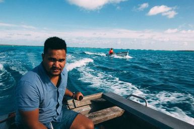 Co-collector Le Naponita Lepaio (Poni) steering an aluminium dinghy, Atafu, Tokelau