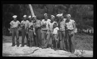 [Servicemen and two children on beach]