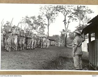 SOGERI, NEW GUINEA. 1943-11-20. STUDENTS MARCHING PAST THE OFFICER COMMANDING, SCHOOL OF SIGNALS, NEW GUINEA FORCE AS THEY MOVE OFF THE PARADE GROUND AFTER THE MORNING PARADE. SHOWN IS: NX35052 ..
