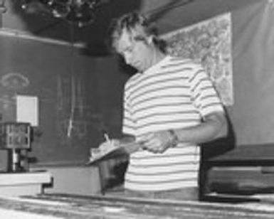 Donald M. Hussong of the Hawaii Institute of Geophysics, who served as the cruise Co-Chief Scientist, is studying a core sample taken aboard the D/V Glomar Challenger (ship) during Leg 60 of the Deep Sea Drilling Project. 1978