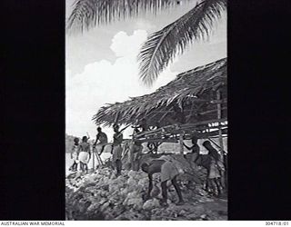 SEGI, NEW GEORGIA, BRITISH SOLOMON ISLANDS PROTECTORATE. C.1944. LOCAL NATIVES BUILD A COVERED EMPLACEMENT FOR COASTWATCHER DONALD KENNEDY. (NAVAL HISTORICAL COLLECTION)