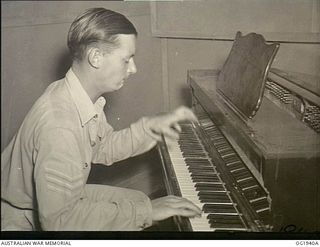 MADANG, NEW GUINEA. C. 1944-10. 424699 SERGEANT (SGT) PHILLIP HARGRAVE, ADELAIDE, SA, AN EMINENT AUSTRALIAN PIANIST IN CIVILIAN LIFE, BROADCASTING OVER RAAF RADIO, THE VOICE OF THE ISLANDS. THE ..