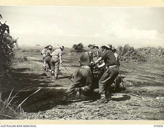 DALLMAN RIVER, NEW GUINEA, 1944-02-23. MEMBERS OF THE 2/14TH FIELD REGIMENT DRAGGING A SHORT 25-POUNDER GUN INTO POSITION