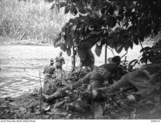 YARA RIVER, NEW BRITAIN, 1945-07-28. MEMBERS OF 2/2 COMMANDO SQUADRON CROSSING THE YARA RIVER DURING A PATROL. THE MEN IN THE FOREGROUND PROVIDE COVERING FIRE WITH OWEN GUNS