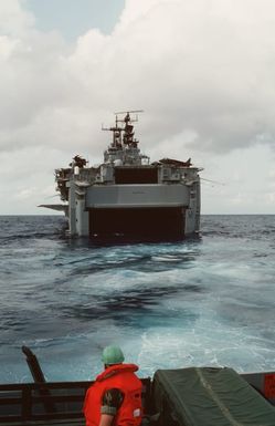 A Marine standing in the back of a truck aboard a landing craft looks toward the open well deck of the amphibious assault ship USS SAIPAN (LHA 2) during Operation Sharp Edge. Marines of the 22nd Marine Expeditionary Unit (22nd MEU) are being sent to the U.S. Embassy in Monrovia, Liberia, to augment security and evacuate U.S. and foreign nationals from the fighting between government and rebel forces