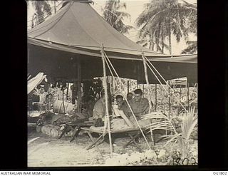 MOMOTE, LOS NEGROS ISLAND, ADMIRALTY ISLANDS, C. 1944-04. PILOTS OF NO. 76 (KITTYHAWK) SQUADRON RAAF IN THE STAND-BY HUT WHERE THEY REST. THEY READ AND AWAIT ANY CALL THAT WILL STIR THEM INTO ..
