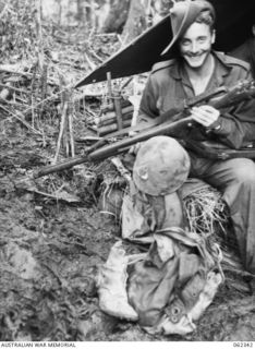 SHAGGY RIDGE, NEW GUINEA. 1943-12-27. LIEUTENANT T. ROBERTS A P38 LIGHTNING PILOT OF THE UNITED STATES AIR FORCE, WHO IS SPENDING HIS 21 DAYS LEAVE WITH THE 2/16TH AUSTRALIAN INFANTRY BATTALION, ..