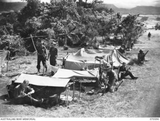 DALLMAN RIVER, NEW GUINEA, 1944-02-21. "SHANTY TOWN", CAMP SITE OF THE 30TH INFANTRY BATTALION RESTING AT THE DALLMAN RIVER. IDENTIFIED PERSONNEL ARE: NX122095 SERGEANT P.A. BUNGATE (1); NX157163 ..