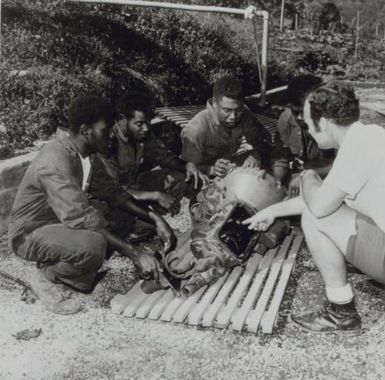 Apprentice mechanics examine a gearbox at the training centre set up to teach indigenes the necessary skills needed for working on the big copper mining project on Bougainville in the Territory of Papua and New Guinea / Australian Information Service photograph