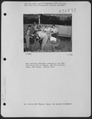 Men receiving Christmas packages at the 38th Bomb Group base at Wagani, near Port Moresby, Papua, New Guinea. January 1943. (U.S. Air Force Number 3A32873)