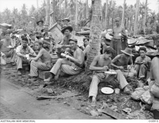 MOMOTE, LOS NEGROS ISLAND, ADMIRALTY ISLANDS. C. 1944-04. GROUND CREWS OF NO. 79 (SPITFIRE) SQUADRON RAAF EAT LUNCH UNDER COCONUT PALM TREES