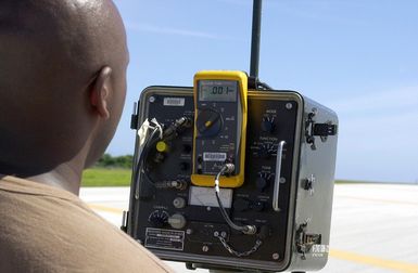 US Air Force (USAF) STAFF Sergeant (SSGT) Carl Campbell, 36th Communication Squadron (CS), reads a portable Instrument Landing System (ILS) receiver on the flight line at Andersen Air Force Base (AFB), Guam. The receiver reads radiation coming out of the antennae that helps aircraft on approach to the runway