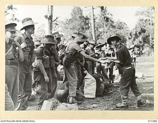 LAE, NEW GUINEA. 1944-05-24. WX40709 WARRANT OFFICER I.G. ABBOTT, REGIMENTAL SERGEANT MAJOR, HEADQUARTERS NEW GUINEA FORCE (1), HANDLING PERSONAL PAPERS TO TROOPS WHO ARE RETURNING TO THE MAINLAND ..