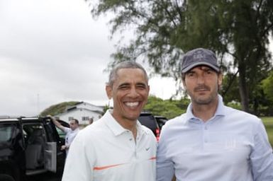 Barack Obama confers with Robert Baker after he plays golf in Kaneohe Bay, Hawaii, December 24, 2014