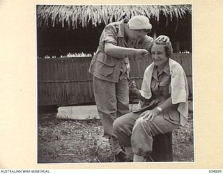 CAPE WOM, WEWAK AREA, NEW GUINEA. 1945-08-02. SISTER R.F. LAWLER (1), CUTTING HAIR OF SISTER M.M. MURPHY (2). THEY ARE MEMBERS OF 104 CASUALTY CLEARING STATION