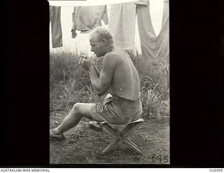 VIVIGANI, GOODENOUGH ISLAND, PAPUA. C. 1944. LEADING AIRCRAFTMAN JEFFRIES RAAF OF BRISBANE, QLD, SITTING ON A MINIATURE STOOL