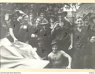 SAMPUN, NEW BRITAIN. 1945-01-13. TROOPS OF THE 6TH FIELD AMBULANCE ENJOYING A CUP OF HOT TEA AFTER UNLOADING THE UNIT STORES DURING A HEAVY RAINSTORM. IDENTIFIED PERSONNEL ARE:- VX108799 PRIVATE ..