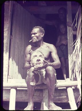 Sepik River man offering a mummified human head for trade, Papua New Guinea, ca. 1951 / Albert Speer