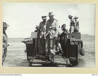 BOUGAINVILLE. 1945-03-31. LORD WAKEHURST, GOVERNOR OF NEW SOUTH WALES (2), COMING ASHORE AT FREDDIE BEACH, SORAKEN, FROM A 42 LANDING CRAFT COMPANY LANDING BARGE. ACCOMPANIED BY MEMBERS OF THE ..