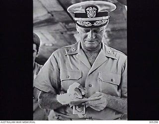 GUAM. 1945-06-07. FLEET ADMIRAL CHESTER W. NIMITZ USN, COMMANDER IN CHIEF, US PACIFIC FLEET AND PACIFIC OCEAN AREAS, SIGNING AN AUTOGRAPH. (NAVAL HISTORICAL COLLECTION)