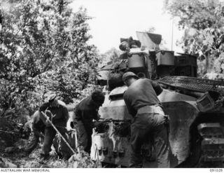 BOUGAINVILLE. 1945-04-17. TANK CREWS OF 2/4 ARMOURED REGIMENT CLEARING MUD AND JUNGLE VINES FROM THE TRACKS OF THEIR MATILDA TANKS. THEY ARE SUPPORTING THE 24 INFANTRY BATTALION ATTACK AT HATAI ..