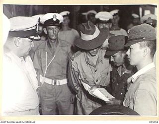 AT SEA, OFF BUIN, BOUGAINVILLE. 1945-08-20. A JAPANESE MESSENGER, ACCOMPANIED BY A CIVILIAN JAPANESE INTERPRETER, READING A MESSAGE FROM LIEUTENANT GENERAL M. KANDA, COMMANDER IMPERIAL JAPANESE 17 ..